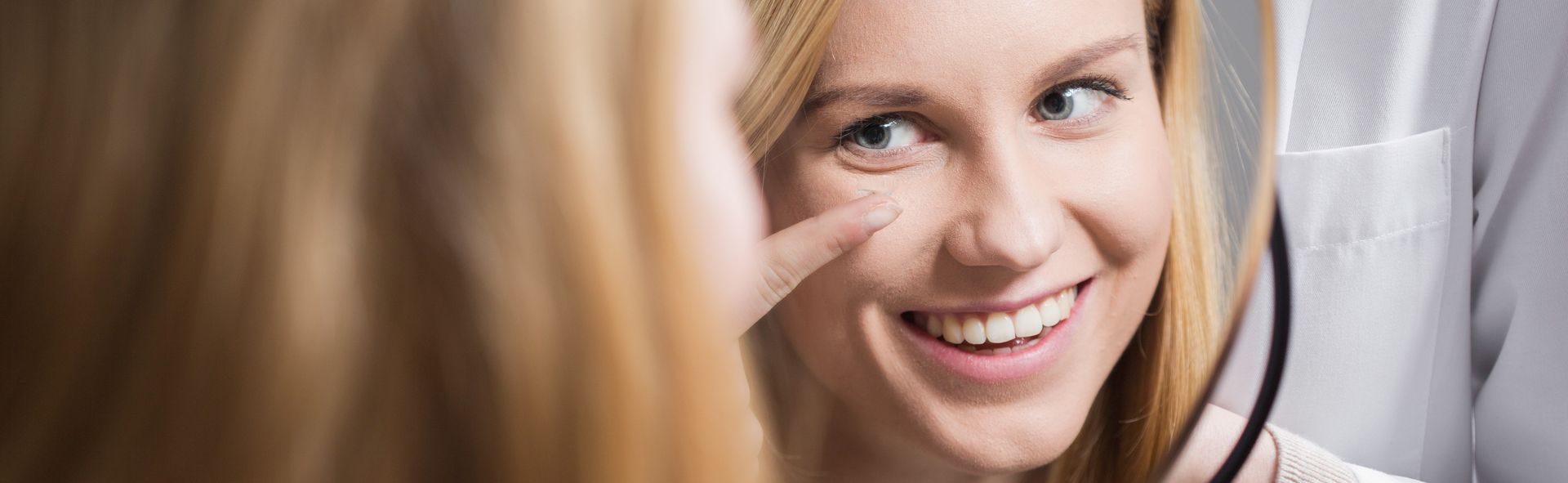 a woman putting a lens in her eye